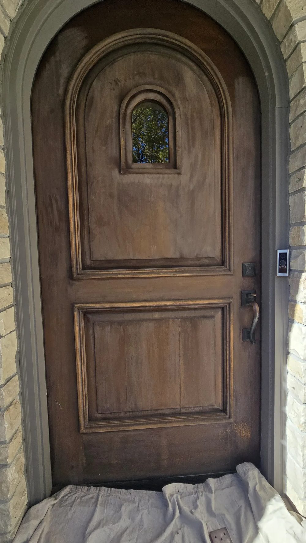 Arched entry door before refinishing, stripped and prepped