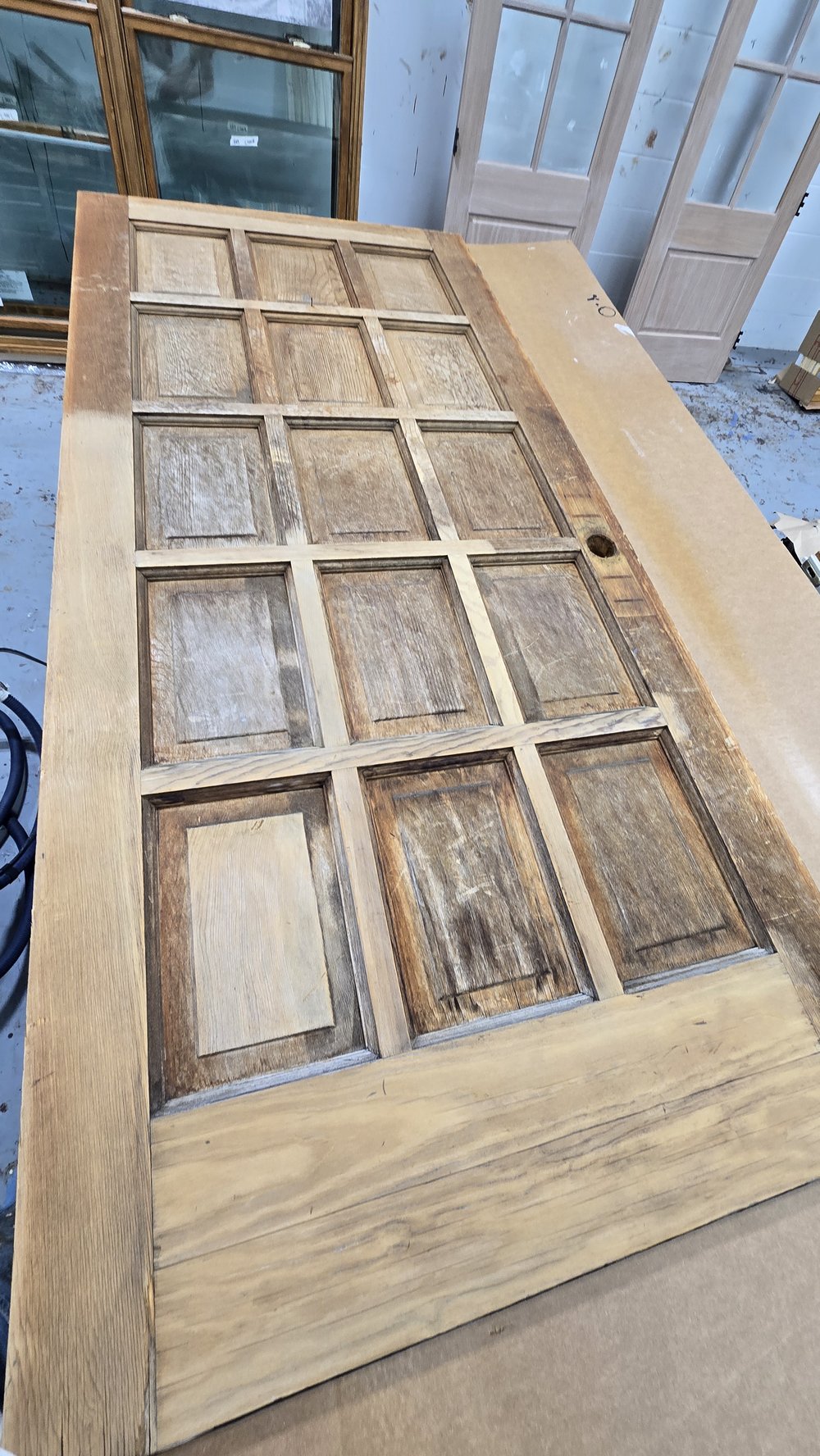 15-panel wood door before refinishing, stripped bare